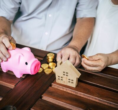 Elderly Couples talking about real estate finance with piggy bank